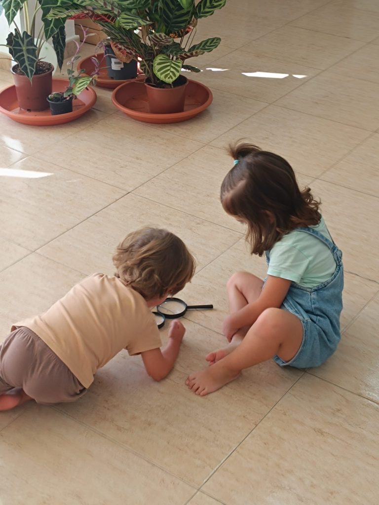 Niños investigando con lupa, aprendizaje por descubrimiento en Vélez-Málaga