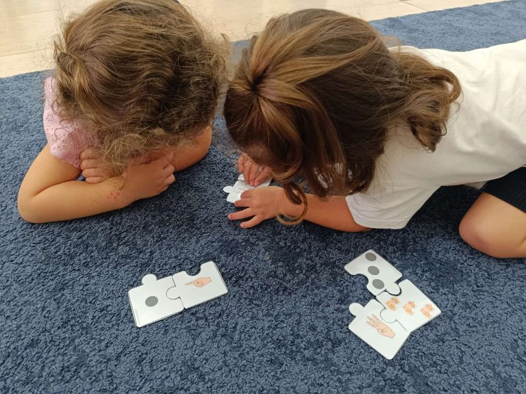 Niñas resolviendo un puzle de sílabas sobre la alfombra