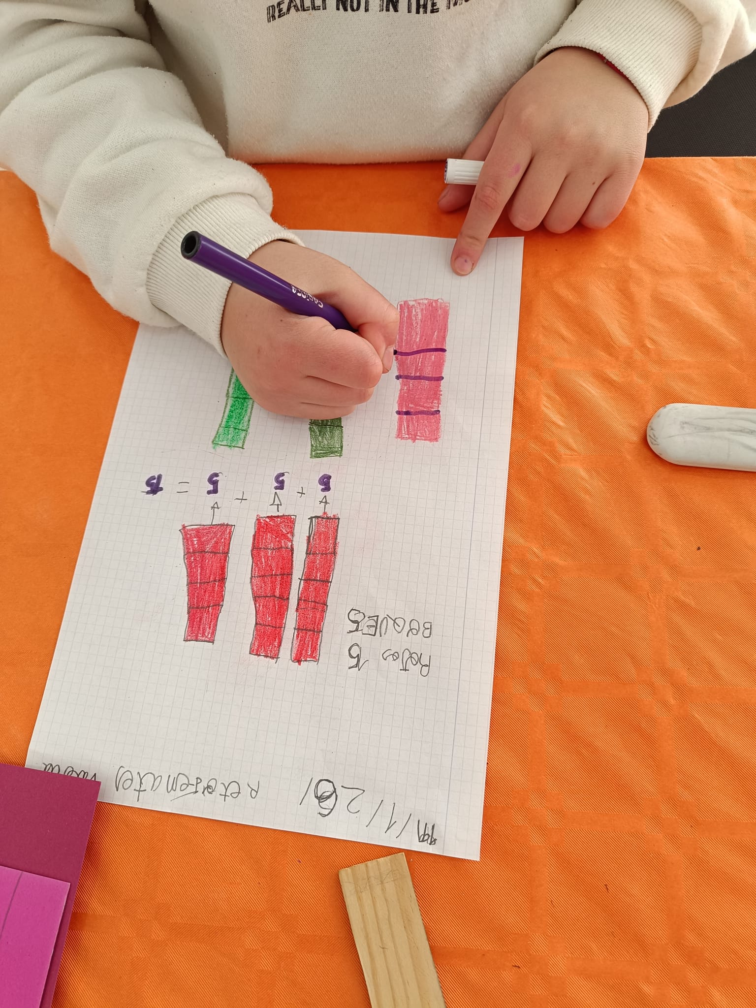 Niño contando y escribiendo números en una ficha durante el apoyo pedagógico