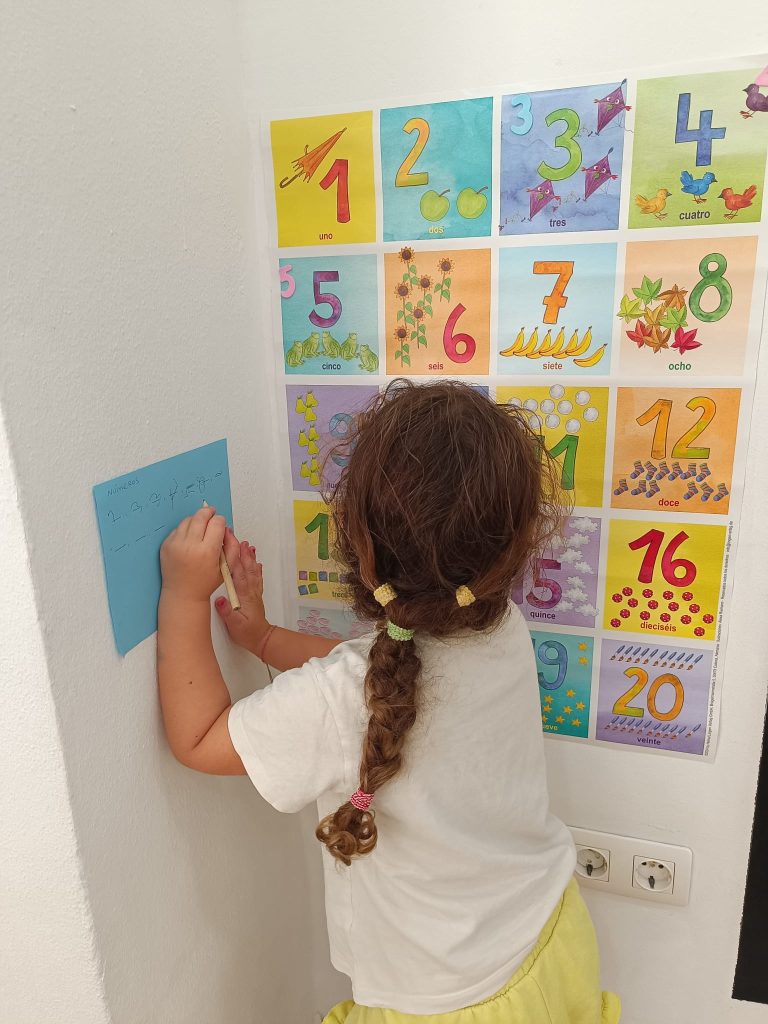 Niña trabajando los números con un panel manipulativo